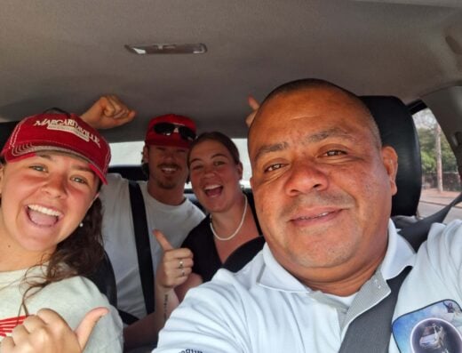 Group of friends enjoying a taxi ride to Popoyo for surfing, smiling and having fun inside a car.