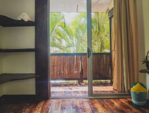 Bright interior with sliding glass door leading to a tropical balcony.
