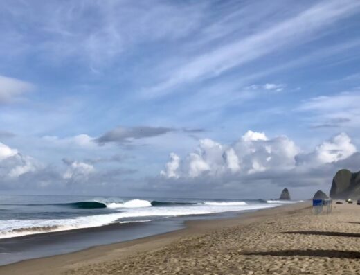 Beach view at Villas San Lorenzo with surf and scenic coastline.