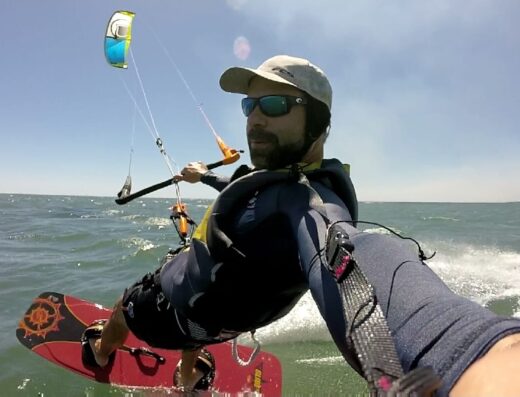 Experienced kitesurfer riding the waves during a lesson at Waverii, showcasing skills and safety gear for optimal learning and adventure.