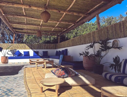 Relaxing outdoor lounge at La Crique Surf House featuring comfortable seating, vibrant cushions, and natural decor, perfect for unwinding after surfing in a tropical setting.