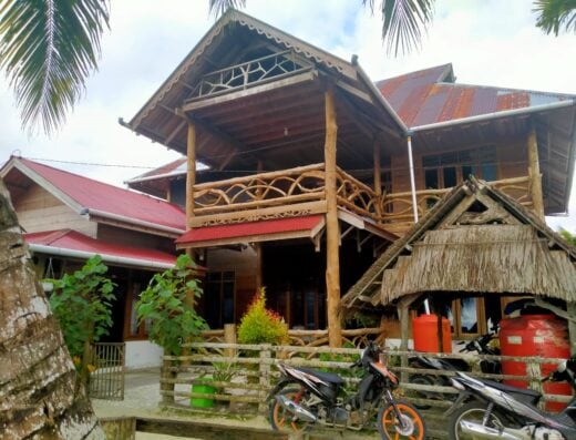 Rustic surf camp house with wooden balconies and tropical surroundings, ideal for surfing enthusiasts at Kutnalek Surf Camp.