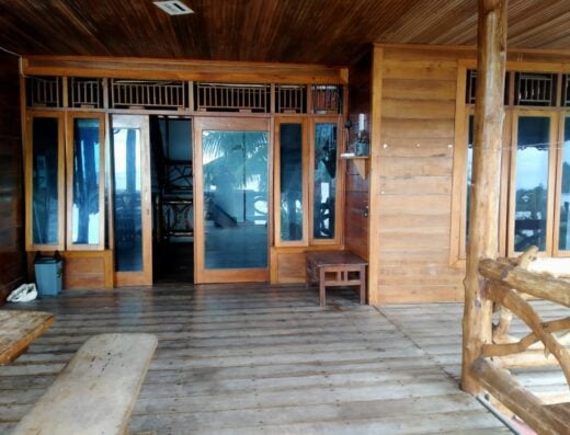 Cozy indoor lounge at Waverii Surf Camp with wooden decor, large windows, and a relaxing atmosphere for surfers and guests.