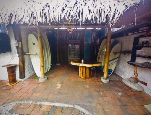 Surfboard rental shop interior showcasing a variety of surfboards, wooden furniture, and tropical decor, perfect for surfers of all levels seeking quality equipment and a relaxed atmosphere.