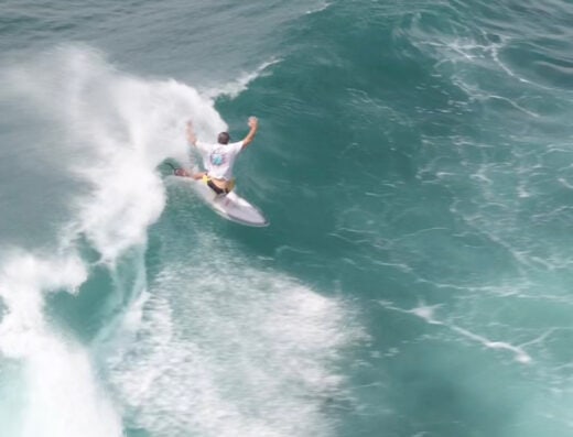 An intermediate surfer riding a wave during a surf lesson at Waverii, demonstrating skill and technique on a clear ocean wave.