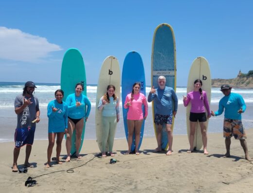 Vibrant group of surfers with colorful surfboards on the beach, ready for an exciting day of surfing, showcasing premium surfboard rentals suitable for all skill levels.