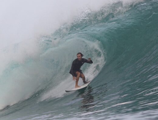 A surfer riding a large wave during a surf lesson, showcasing skill and ocean conditions at Waverii. Perfect for surf enthusiasts and beginners learning to ride waves.