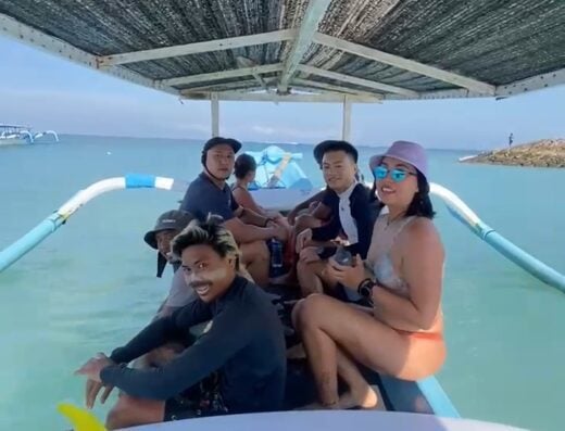 A group of friends enjoying a surf lesson on a boat in Bali, with surfboards and clear turquoise water in the background. Perfect for adventure and surfing enthusiasts.