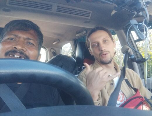 Two men inside a transportation vehicle at Padang airport and harbor, providing reliable drop-off services in West Sumatera.