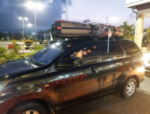Transport vehicle with kayak on roof rack at Padang airport and harbor, West Sumatera.